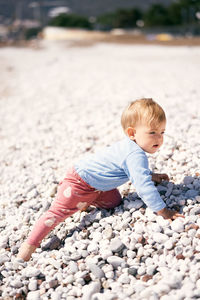 Full length of cute baby girl on pebbles