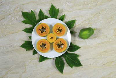High angle view of fruits and leaves on table