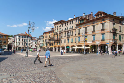 People walking on street amidst buildings in town