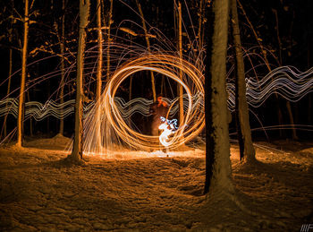 Blurred motion of man with fire crackers at night