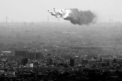 Japan air self defense force aerobatic team blue impulse flying in formation over the city