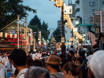 People on street in city against sky