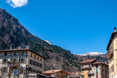 Buildings in city against clear blue sky