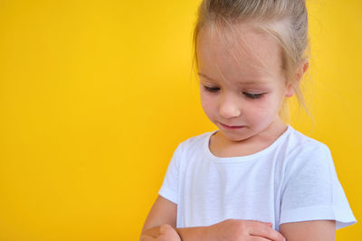 Close-up of young woman against yellow background