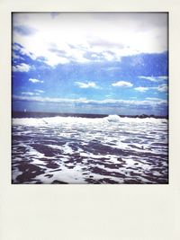 Snow covered landscape against cloudy sky