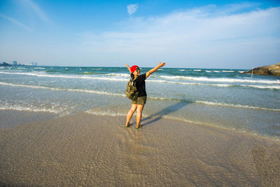 Full length of woman on beach against sky