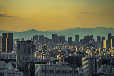 Buildings in city against sky during sunset