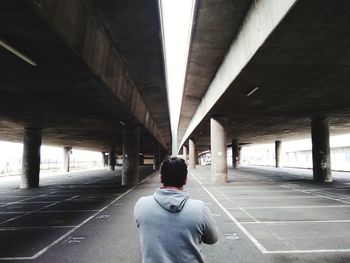 Rear view of man standing on bridge
