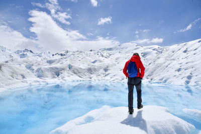 Rear view of person standing on snow covered mountain