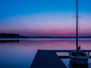 Pier on sea against sky at sunset