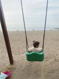 Boy swinging at playground