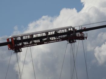 Low angle view of cranes against sky