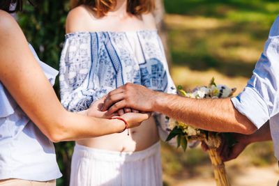 Midsection of couple holding hands