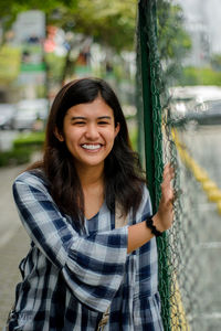 Portrait of smiling young woman standing outdoors