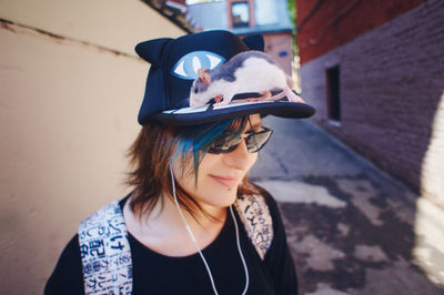 Young woman wearing hat. teenager with a pet. student. rat