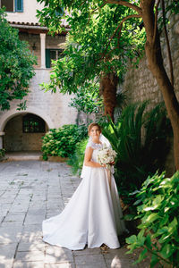 Portrait of woman standing against tree