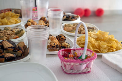 Table with cakes and glasses for drinks and napkins