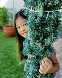 Close-up portrait of girl holding plant in yard