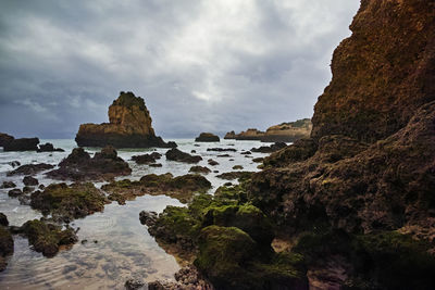 Rock formations by sea against sky