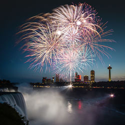 Low angle view of firework display at dusk