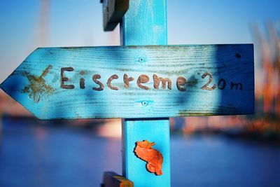 Close-up of information sign against blue sky