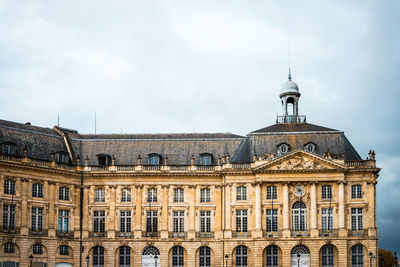 High section of old building against cloudy sky