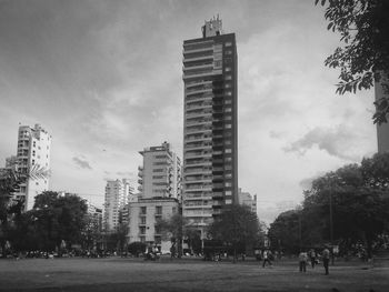 Buildings in city against cloudy sky