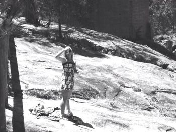 Woman standing on tree trunk