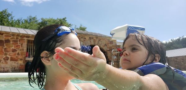 Portrait of boy drinking from swimming pool