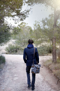 Rear view of man walking on road