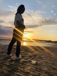 Man standing on beach during sunset