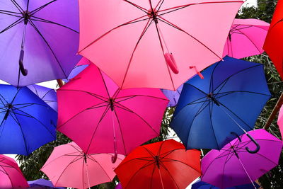 Low angle view of multi colored umbrella against blue sky