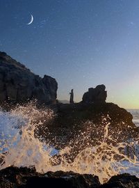 Scenic view of rock formations against sky at night