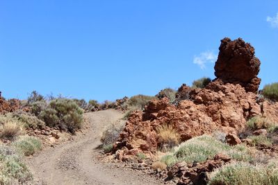 Rock formations on landscape against clear blue sky