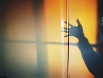 Shadow of person hand on window