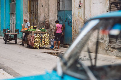 People in shopping cart in city