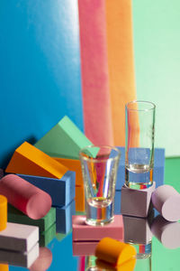 Close-up of hand holding multi colored glass on table