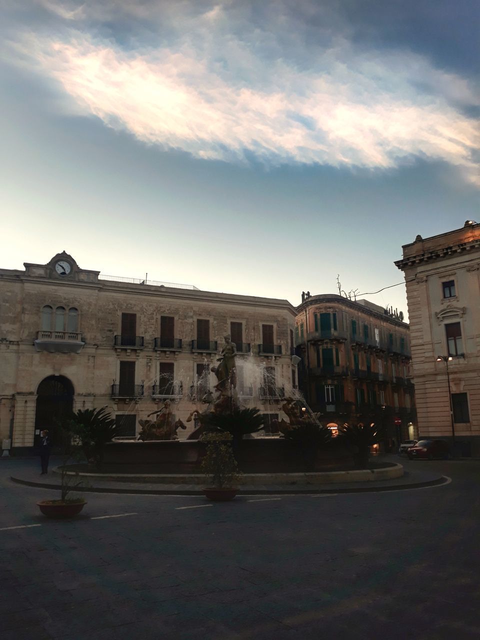 BUILDINGS BY STREET AGAINST SKY AT SUNSET