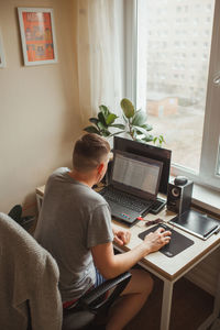 High angle view of man working on laptop at home