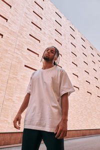 Low angle view of man standing against wall