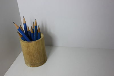 Close-up of colored pencils on table against white background