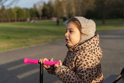 Side view of girl with push scooter