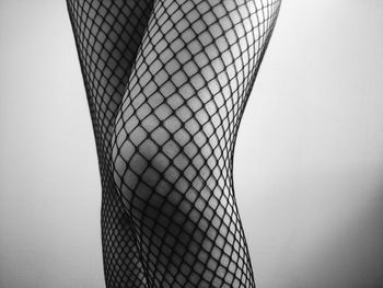 Midsection of woman wearing fishnet stockings