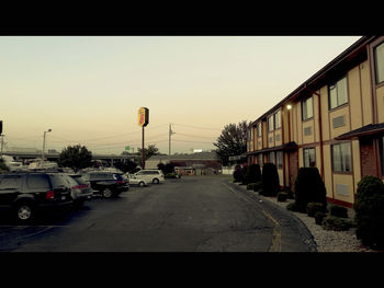 Cars on road amidst buildings against clear sky