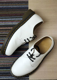 High angle view of white leather shoes on hardwood floor