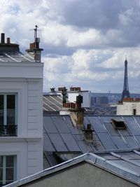 Buildings in city against cloudy sky