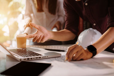 Midsection of woman using laptop on table