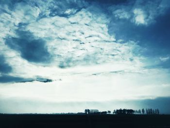 Low angle view of silhouette trees on field against sky