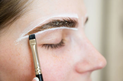 Close-up of woman applying make-up