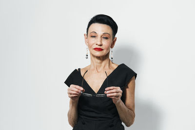 Portrait of young woman standing against white background